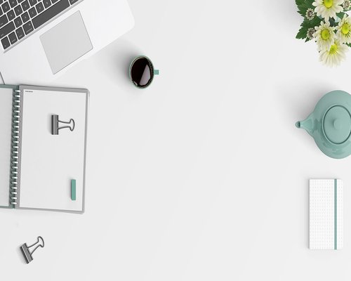 A minimalist office desk setup with a clean notebooks and stationary under soft lighting